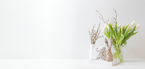 White spring tulips in a vase, easter eggs on a white table. Mock up for displaying works