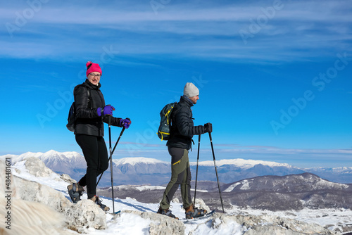 Hikers walk with snowshoes to the snow-capped peak,