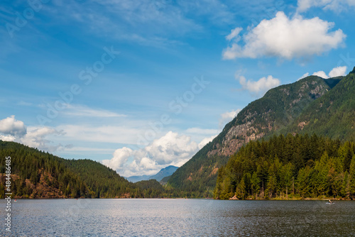 Summer day on the lake between forested mountains