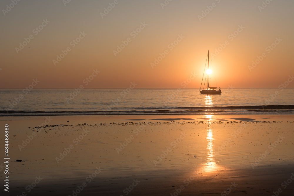 Sailing boat on the beach at sunset with the sun in the background, Tarifa, Cadiz, Andalusia, Spain