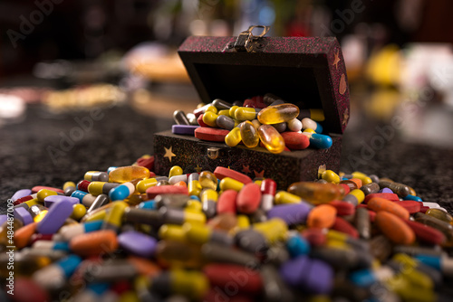Fototapeta Naklejka Na Ścianę i Meble -  Treasure box filled with prescription medication painkillers tablets pills and capsules