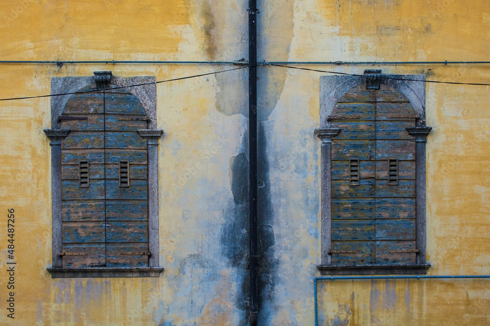 Two wooden shuttered windows in a medieval building in the historic centre of Belluno, in Veneto, north east Italy

