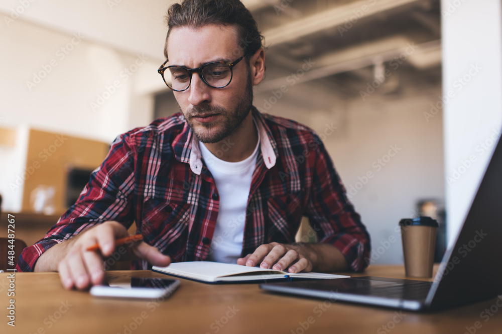 Millennial businessman working at desk in office Millennial businessman working at desk in office