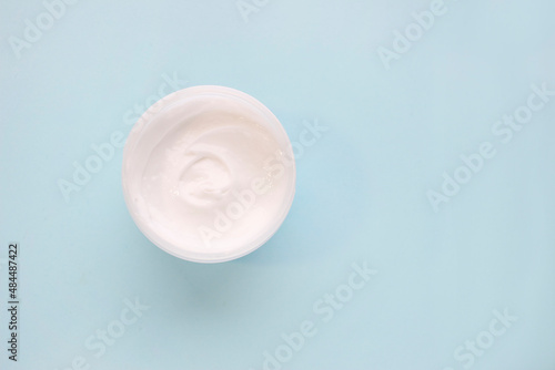 Empty white plastic tube compression bottle on blue background. Packaging of cream  lotion  gel  facial foam or skin care. Cosmetic beauty product breadboard branding. Copy space.