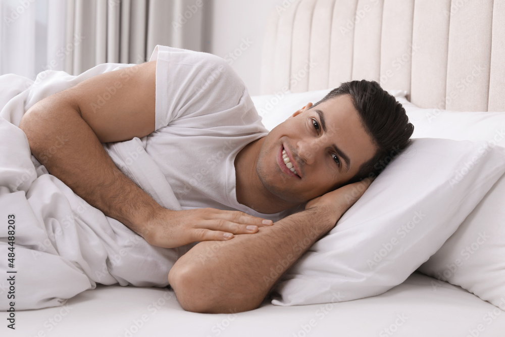 Happy man lying in bed at home Happy man lying in bed at home