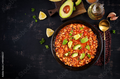 Chili con carne in bowl on dark background. Mexican cuisine. Top view, above