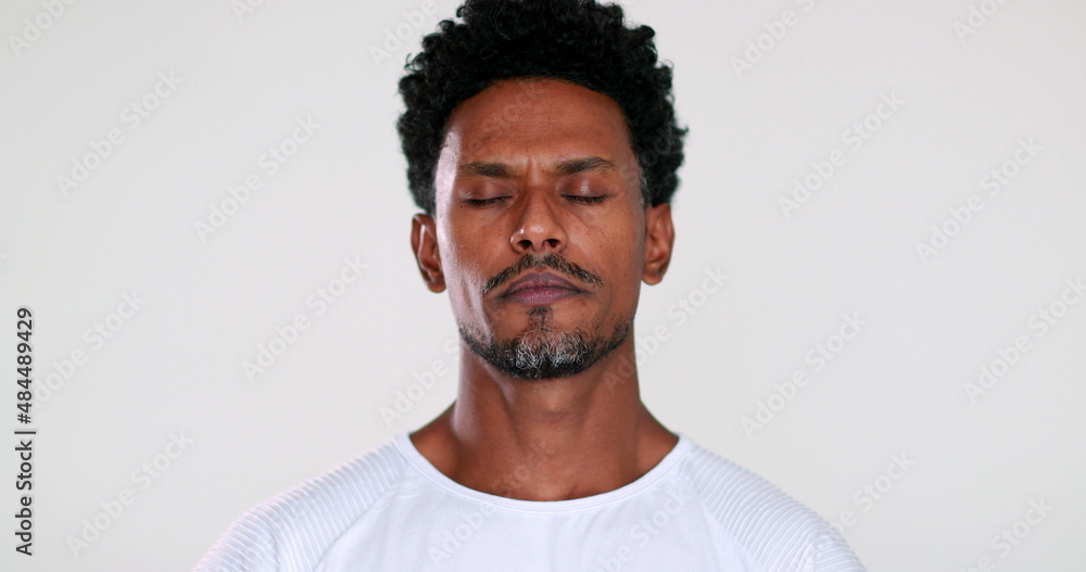 Obraz premium African man closing eyes trying to relax and contemplate life in meditation mindful