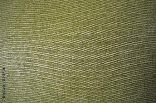 Closeup green fabric texture with copy space. Selective focus upholstery for furniture. Wallpaper and background. Thick gray material for the interior.