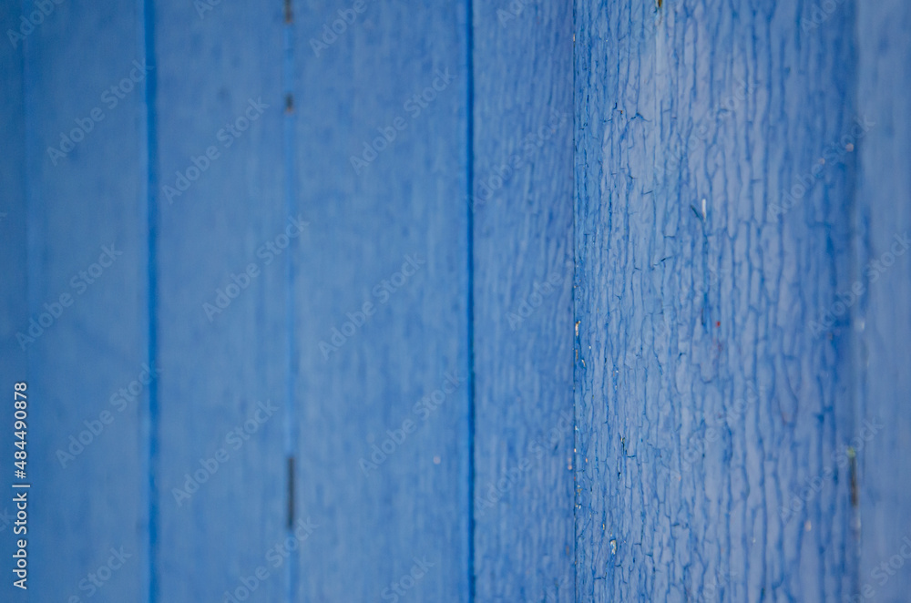 Selective focus old blue cracked paint. The texture of the old emerald paint with cracks. Dried in the sun and cracked color on the wooden shutters of country house. Peeling coating. Selective focus old blue cracked paint. The texture of the old emerald paint with cracks. Dried in the sun and cracked color on the wooden shutters of country house. Peeling coating.