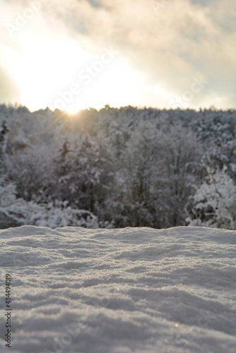 Deep snow with sunrise behind the blurred trees