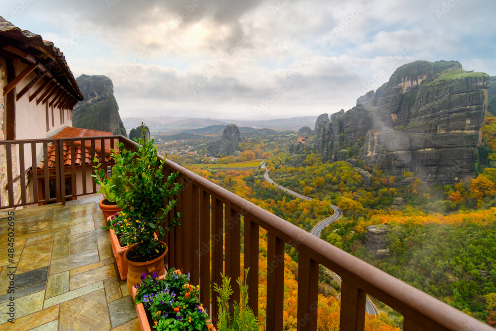 View from the Monastery of St. Barbara or Roussanou at Meteora, Greece under foggy, cloudy skies with leaves turning fall colors at autumn.
