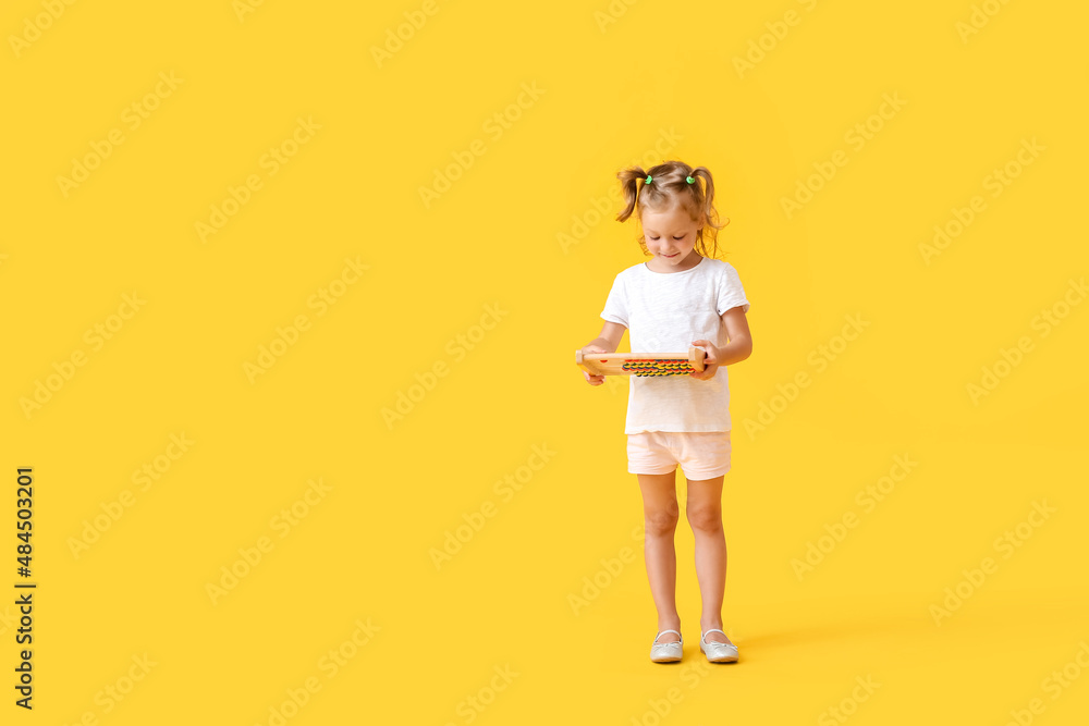 Adorable little girl with abacus on yellow background Adorable little girl with abacus on yellow background