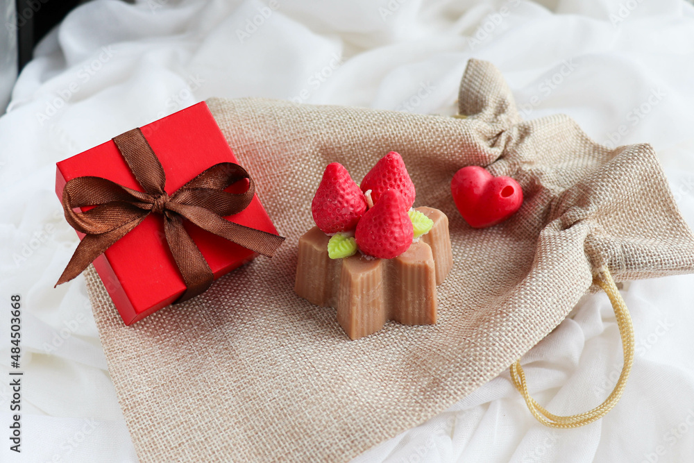 gift concept for valentine's day. handmade natural soy wax candle in the shape of a strawberry cake gift concept for valentine's day. handmade natural soy wax candle in the shape of a strawberry cake