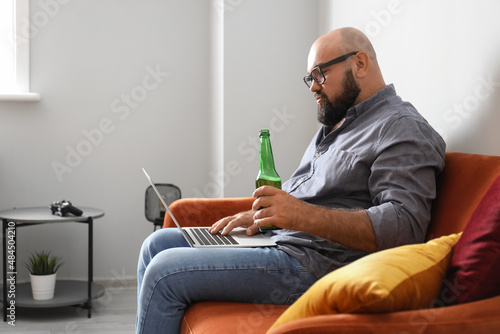 Man with laptop drinking be...
