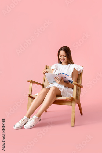 Pretty young woman reading ...
