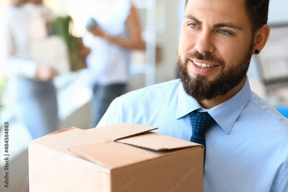 Handsome man holding box with things in office on moving day, closeup Handsome man holding box with things in office on moving day, closeup
