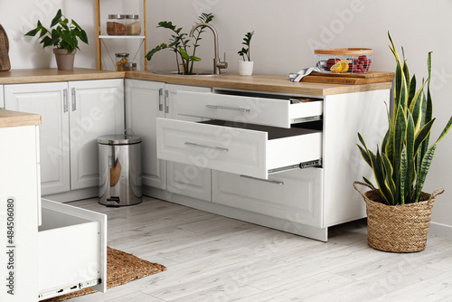 Interior of stylish kitchen with opened drawers