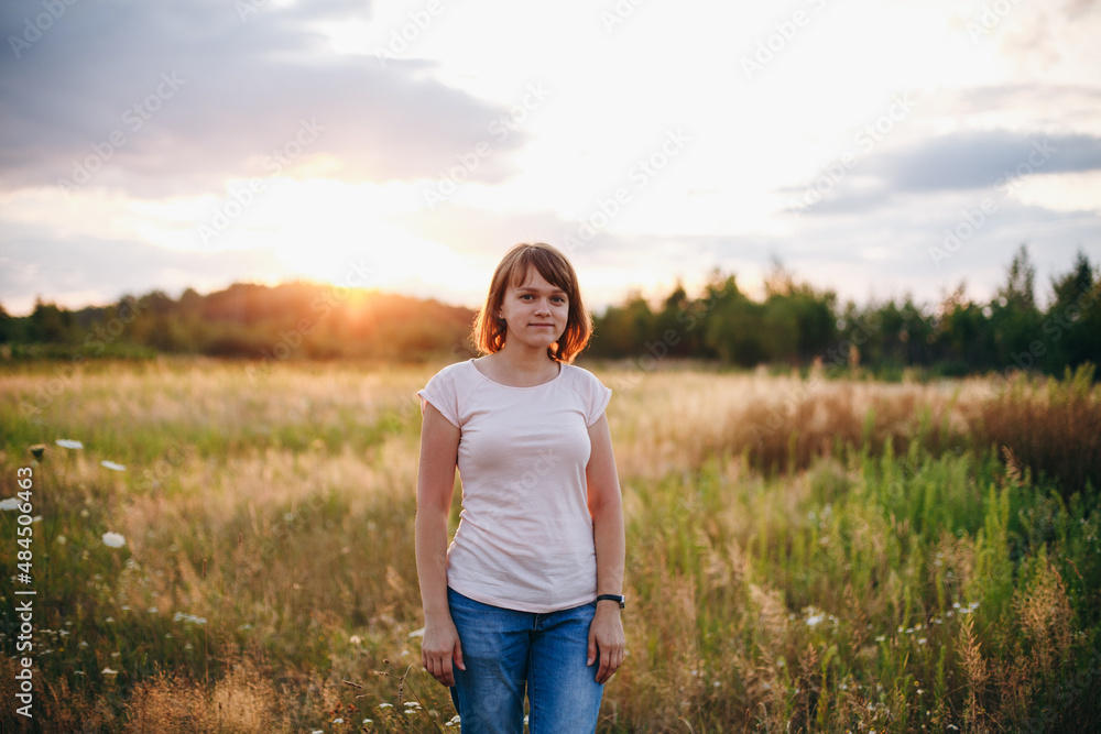 Beautiful girl standing in a field at sunset
Beautiful girl standing in a field at sunset