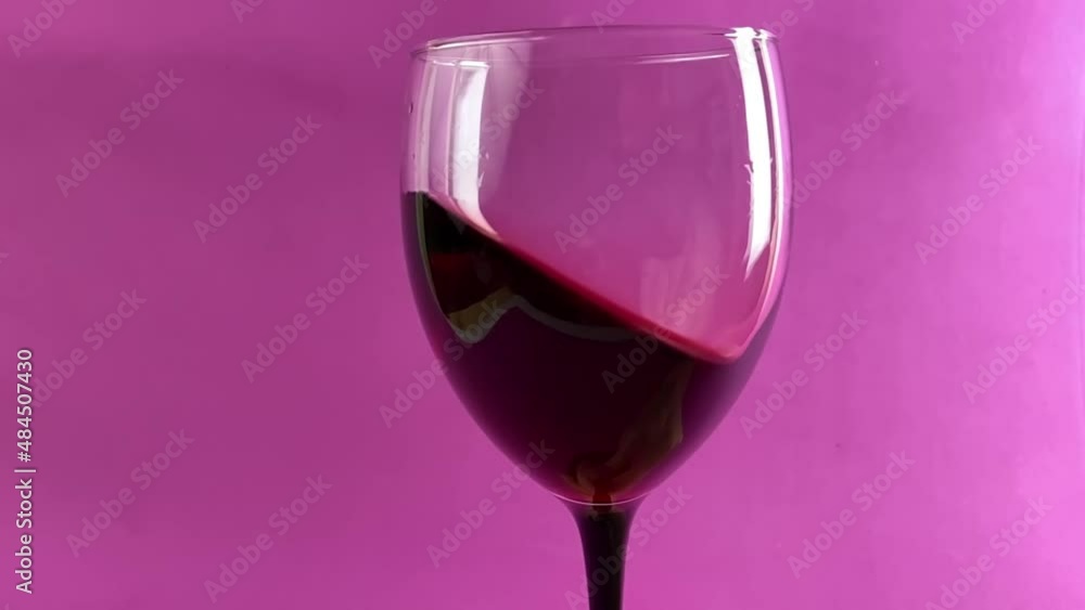 Waving red wine in a glass on defocused background. Beautiful stock footage for wine commercial. Close up video of wine mixing process inside goblet. Shot in slow motion. Waving red wine in a glass on defocused background. Beautiful stock footage for wine commercial. Close up video of wine mixing process inside goblet. Shot in slow motion.