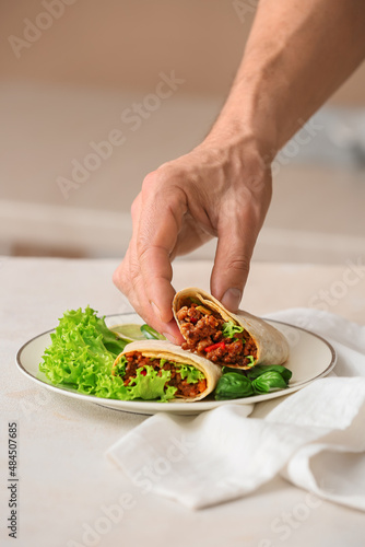 Wallpaper Mural Man eating tasty burrito at table Torontodigital.ca