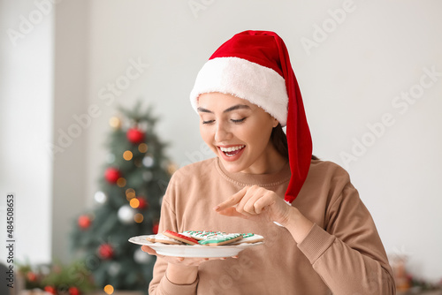 Young woman in Santa hat ho...
