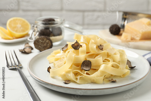 Delicious pasta with truffle slices served on white table