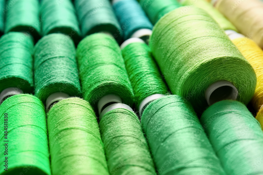 Closeup view of spools with green threads Closeup view of spools with green threads