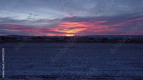 Drone shot of sunset over snowy field