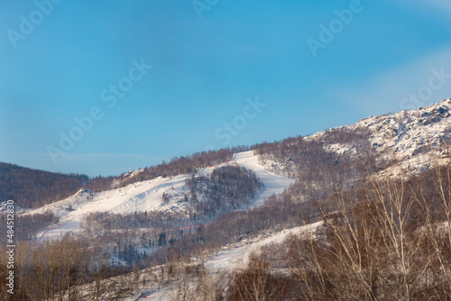 A mountain with equipped trails for skiing. Mount Abzakovo in winter. Ski resort in the Ural mountains. Mountain close-up