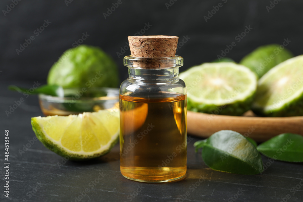 Bottle of bergamot essential oil on dark table, closeup Bottle of bergamot essential oil on dark table, closeup