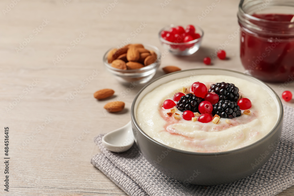 Delicious semolina pudding with berries on wooden table, space for text Delicious semolina pudding with berries on wooden table, space for text