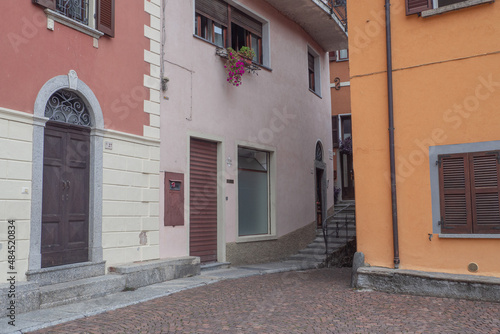 Traditional colourful houses in empty street with stairs remote village in lake como, italy