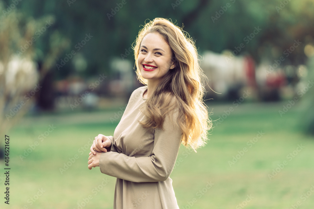 woman in her thirties in brown dress laughs posing for the camera woman in her thirties in brown dress laughs posing for the camera