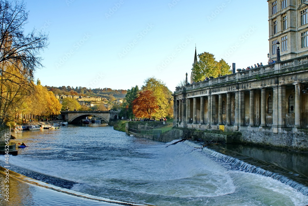Georgian architecture on the bank of the River Avon in Bath, England, surrounded by autumn foliage