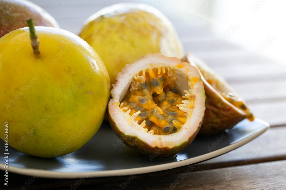 Exotic passion fruit on plate, macro of half sliced sweet maracuja