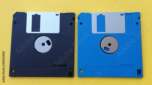 Colored magnetic floppy disks on yellow background.