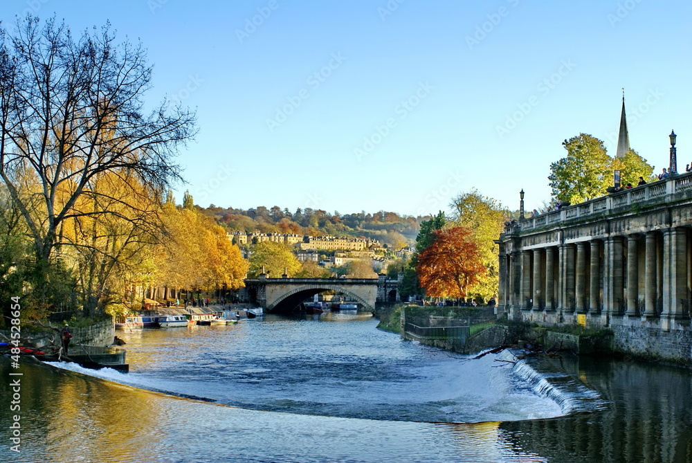River Avon surrounded by Georgian architecture and autumn foliage, with a bridge over it, in Bath, England
