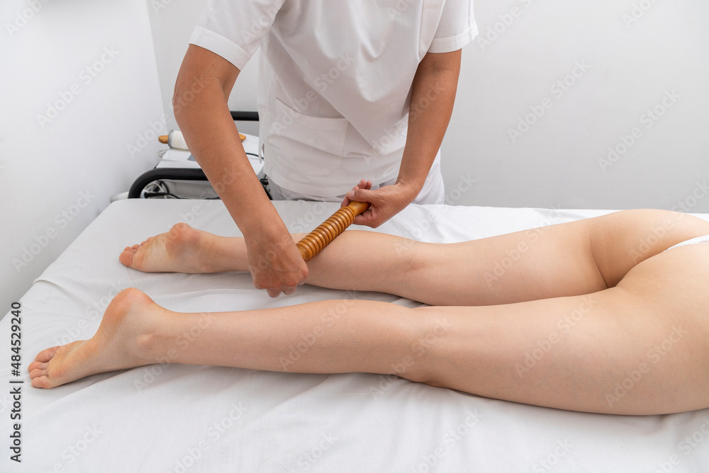 Fototapeta premium young woman in an aesthetic center undergoing a treatment for the beauty of the skin and body with the wood therapy method applied by an aesthetic professional
