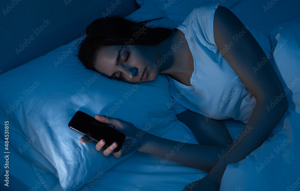 Tired woman falling asleep after browsing smartphone Tired woman falling asleep after browsing smartphone