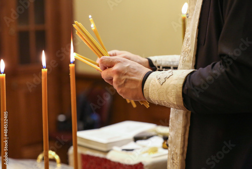 the priest lights candles for the rite of baptism