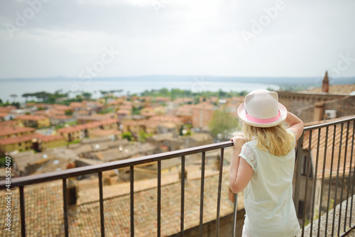 Young girl exploring medieval streets of picturesque resort town Bolsena  situated on the shores of Italy s largest lake  Lago Bolsena  Italy.