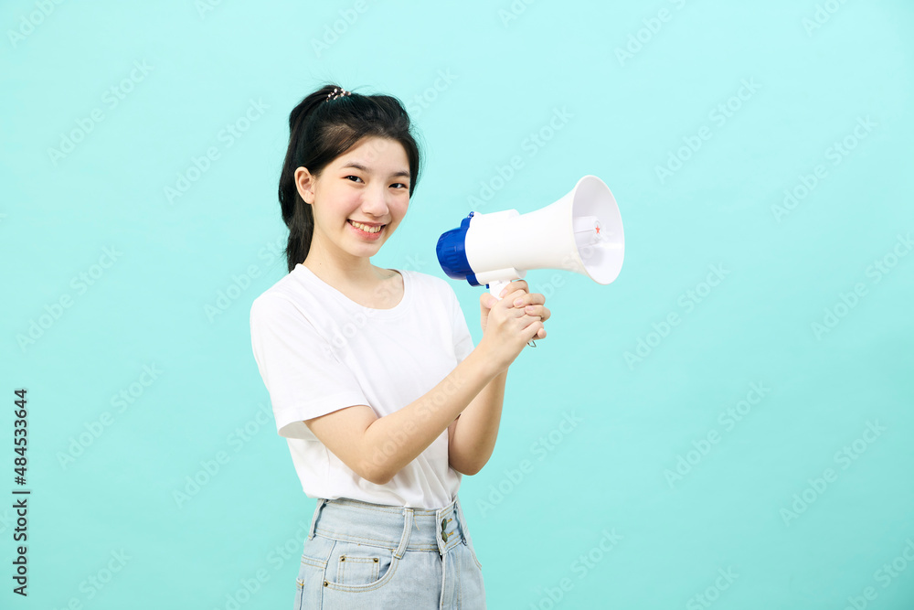 Asian woman holding megaphone on blue background Asian woman holding megaphone on blue background