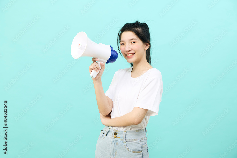 Asian woman holding megaphone on blue background Asian woman holding megaphone on blue background