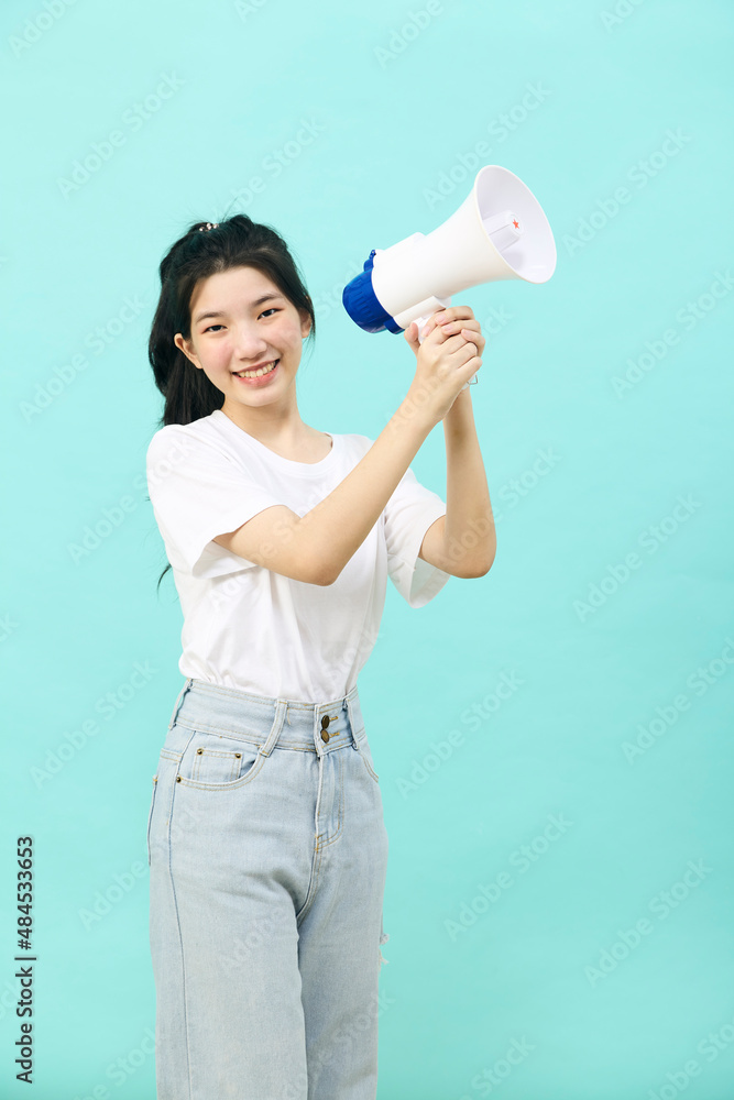Asian woman holding megaphone on blue background Asian woman holding megaphone on blue background