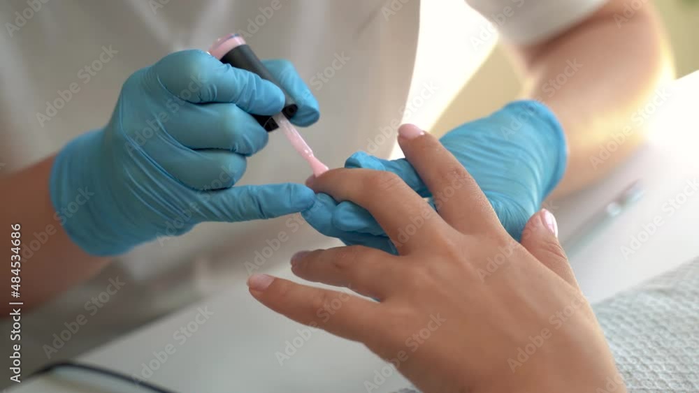 Pretty woman on the procedure of paints the nails. Decoration polish on the nail. Cosmetology small business concept. close up view. 4k footage Pretty woman on the procedure of paints the nails. Decoration polish on the nail. Cosmetology small business concept. close up view. 4k footage