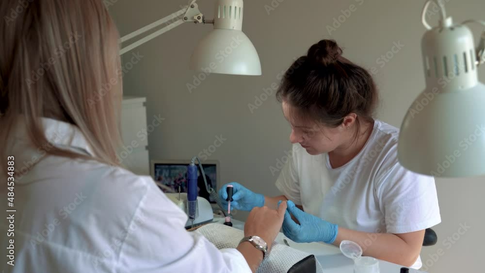 Professional manicure master with gloves applies varnish to nails during the manicure procedure. Small business in covid 19 pandemic. 4k footage Professional manicure master with gloves applies varnish to nails during the manicure procedure. Small business in covid 19 pandemic. 4k footage