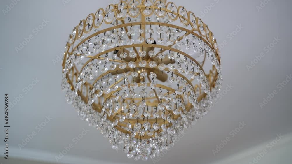 Tilt down luxurious Golden chandelier with crystal gemstone, Hanging on white ceiling, Slow motion Tilt down luxurious Golden chandelier with crystal gemstone, Hanging on white ceiling, Slow motion