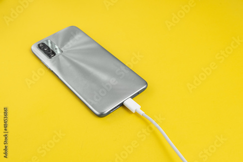 Grey cell phone connected to USB cable type C - Charging