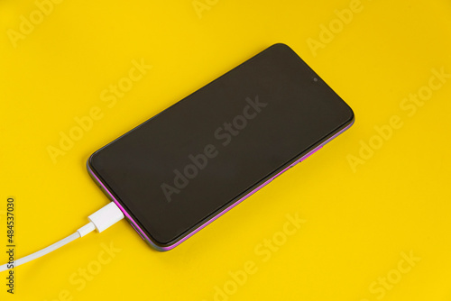 Pink cell phone connected to USB cable type C - Charging