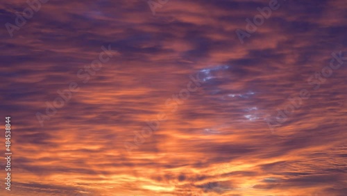 Orange sunset clouds running over the sky. Time lapse